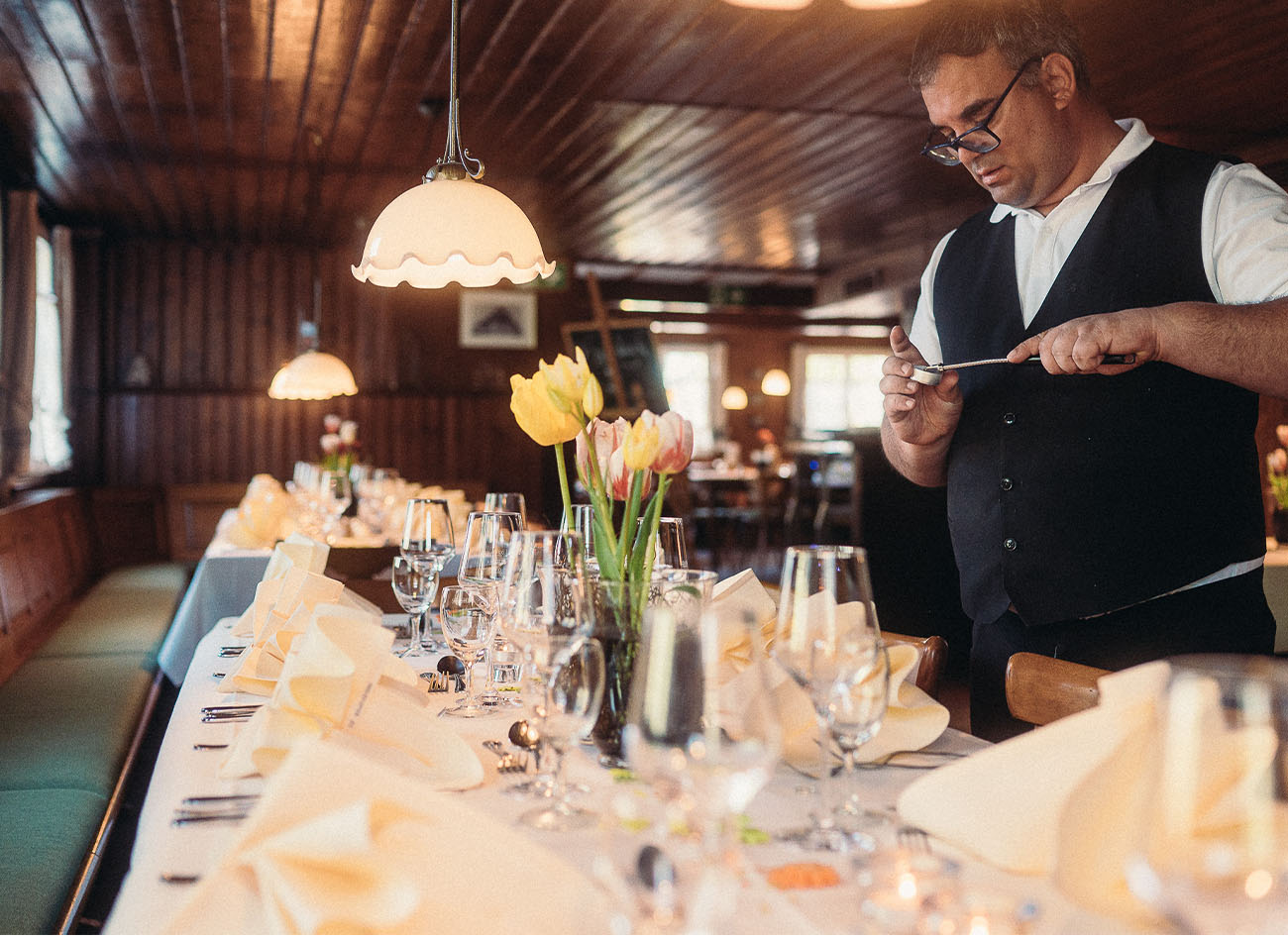Servicekraft mit Behinderung deckt den festlichen Tisch ein.