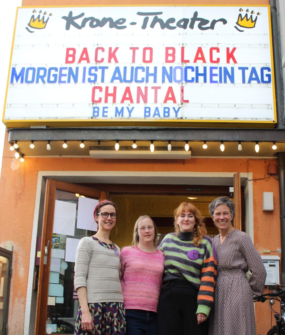 Vier Frauen vor dem Eingang des Kino Krone Theater in Titisee-Neustadt. Über der Tür wird der Film "Be my Baby" angekündigt. Die Frauen von links nach rechts: Kommunale Inklusionsvermittlerin von Tiitsee-Neustadt, Carina Kühne - Hauptdarstellerin im Film, Julia Tamm als Behindertenbeauftragte im Landkreis Breisgau-Hochschwarzwald, Alexandra Kaufmann vom Hofgut Himmelreich.