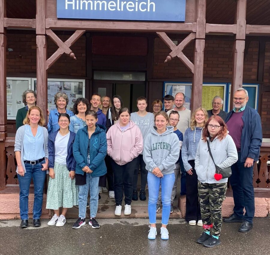 Gruppenbild mit12 junge Menschen und den Mitarbeitenden der Akademie Himmelreich vor der Akademie Himmelreich